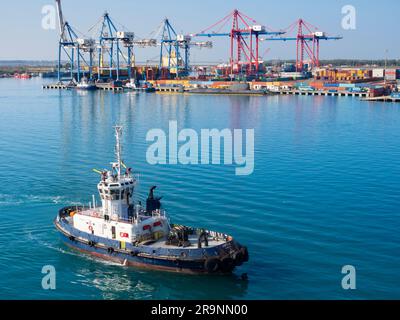 Limassol ist nach Nikosia die zweitgrößte Stadt Zyperns. Hier sehen wir seinen Containerhafen bei Sonnenaufgang, ein Schlepper vorne Stockfoto