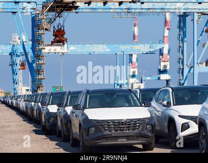 Schlangen von gerade eingetroffenen importierten Autos am Hafen in Haifa, Israel, warten auf Lieferung und Umladung. Wir können auch einige der massiven Gantry sehen Stockfoto