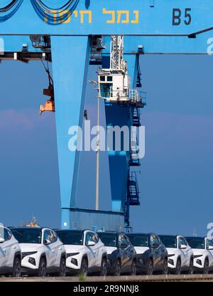 Schlangen von gerade eingetroffenen importierten Autos am Hafen in Haifa, Israel, warten auf Lieferung und Umladung. Wir können auch einige der massiven Gantry sehen Stockfoto