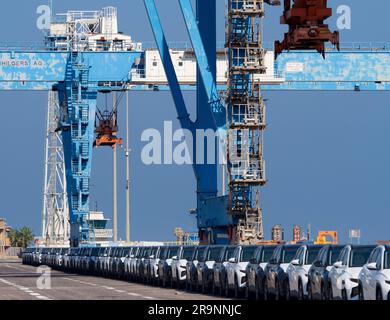 Schlangen von gerade eingetroffenen importierten Autos am Hafen in Haifa, Israel, warten auf Lieferung und Umladung. Wir können auch einige der massiven Gantry sehen Stockfoto