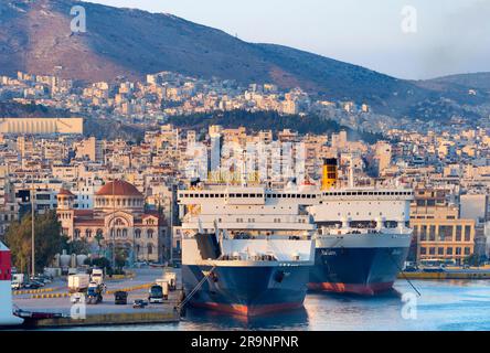 Piräus ist eine geschäftige mediterrane Hafenstadt im Stadtgebiet von Athen in der griechischen Region Attika. Hier sehen wir es bei Sonnenuntergang, von unserem cr aus gesehen Stockfoto