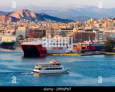 Piräus ist eine geschäftige mediterrane Hafenstadt im Stadtgebiet von Athen in der griechischen Region Attika. Hier sehen wir es bei Sonnenuntergang, von unserem cr aus gesehen Stockfoto