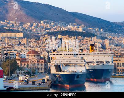 Piräus ist eine geschäftige mediterrane Hafenstadt im Stadtgebiet von Athen in der griechischen Region Attika. Hier sehen wir es bei Sonnenuntergang, von unserem cr aus gesehen Stockfoto