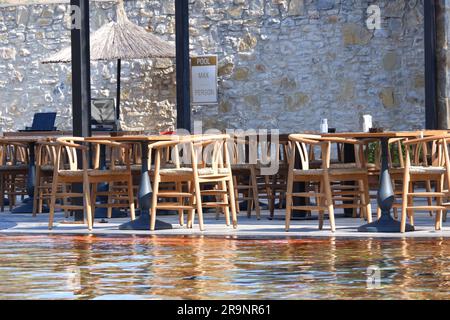 Holztische und -Stühle am Pool im Hotel Stockfoto