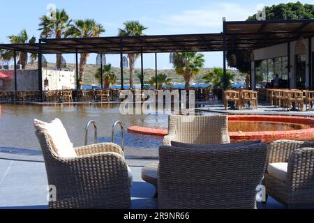 Holztische und -Stühle am Pool im Hotel Stockfoto