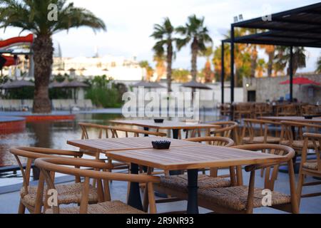 Holztische und -Stühle am Pool im Hotel Stockfoto