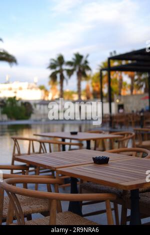 Holztische und -Stühle am Pool im Hotel Stockfoto