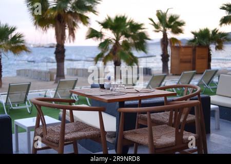 Holztische und -Stühle am Pool im Hotel Stockfoto