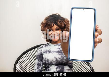 Wunderschöne afrikanische Dame mit großem Telefonbildschirm Stockfoto