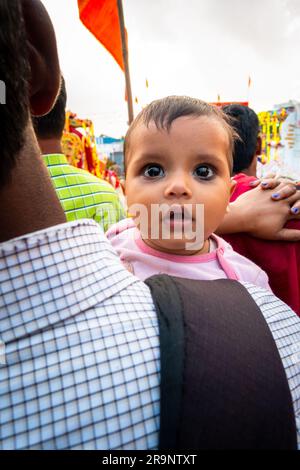 Oktober 19. 2022, Dehradun, Uttarakhand, Indien. Ein süßer indischer Kinderwächter über der Schulter seines Vaters auf der Straße. Stockfoto