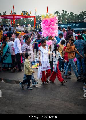 Oktober 19. 2022, Dehradun, Uttarakhand, Indien. Eine indische Mutter, die ihre Kinder zu einer Festmesse mitnimmt. Stockfoto