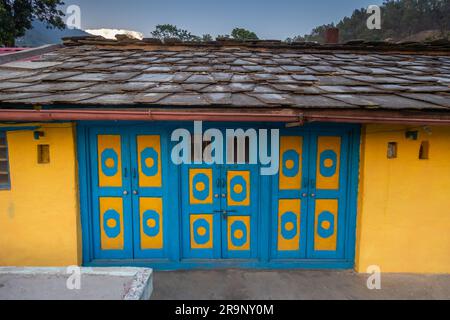 Außenansicht des Altenhauses mit offener blauer und gelber Tür an sonnigen Tagen im kleinen Dorf uttarakhand Stockfoto