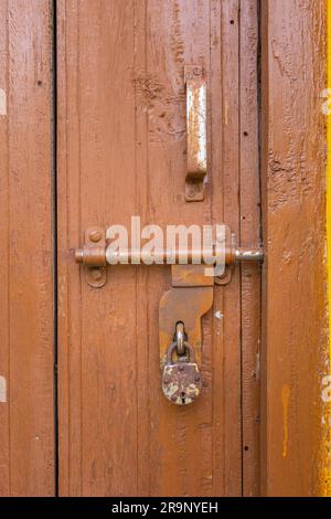 Rostiges Vorhängeschloss an einer alten Holztür des Hauses, Uttarakhand Stockfoto