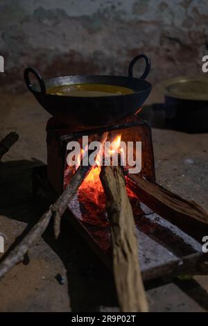 Ländliche Küche. Traditionelle Herde, die von Bewohnern des ländlichen Indiens verwendet werden, mit Holz betrieben, Kochen von Speisen auf dem Herd mit trockenen Blättern und Holz im Dorf Stockfoto