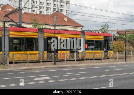 warschau, polen. 13. juni 2023: Erleben Sie effizienten städtischen Transport mit warschaus lebhaften gelben Straßenbahnen, die nahtlos durch den Verkehr A navigieren Stockfoto