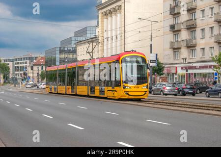 warschau, polen. 13. juni 2023: Erleben Sie effizienten städtischen Transport mit warschaus lebhaften gelben Straßenbahnen, die nahtlos durch den Verkehr A navigieren Stockfoto