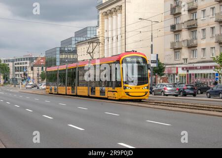 warschau, polen. 13. juni 2023: Erleben Sie effizienten städtischen Transport mit warschaus lebhaften gelben Straßenbahnen, die nahtlos durch den Verkehr A navigieren Stockfoto