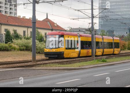 warschau, polen. 13. juni 2023: Erleben Sie effizienten städtischen Transport mit warschaus lebhaften gelben Straßenbahnen, die nahtlos durch den Verkehr A navigieren Stockfoto