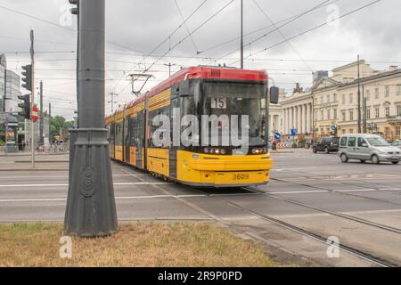 warschau, polen. 13. juni 2023: Erleben Sie effizienten städtischen Transport mit warschaus lebhaften gelben Straßenbahnen, die nahtlos durch den Verkehr A navigieren Stockfoto