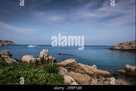 Rhodos, Griechenland - 27. Mai 2023: Malerische Küstenlandschaft in Kalithea, Rhodos, Griechenland. Segelboote in der Bucht. Stockfoto