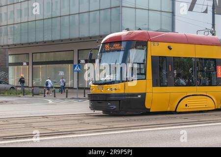 warschau, polen. 16. juni 2023: Erleben Sie effizienten städtischen Transport mit warschaus lebhaften gelben Straßenbahnen, die nahtlos durch den Verkehr A navigieren Stockfoto