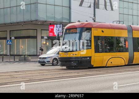 warschau, polen. 16. juni 2023: Erleben Sie effizienten städtischen Transport mit warschaus lebhaften gelben Straßenbahnen, die nahtlos durch den Verkehr A navigieren Stockfoto