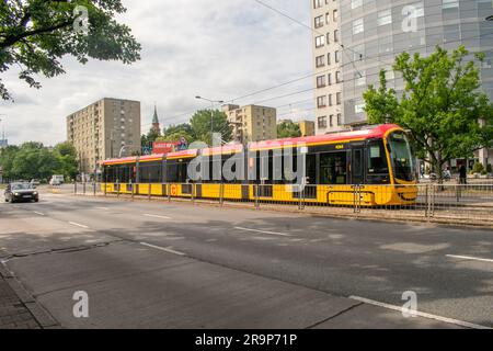 warschau, polen. 17. juni 2023: Erleben Sie effizienten städtischen Transport mit warschaus lebhaften gelben Straßenbahnen, die nahtlos durch den Verkehr A navigieren Stockfoto