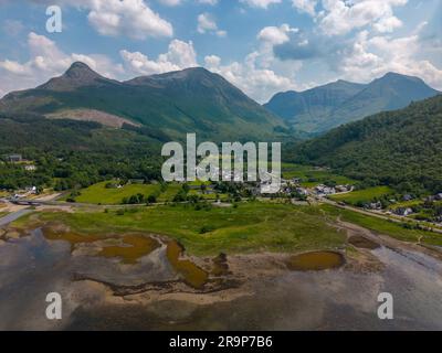 Luftdrohnenfoto des kleinen Dorfes Glencoe. Glencoe liegt zwischen den Bergen der schottischen Highlands. Stockfoto