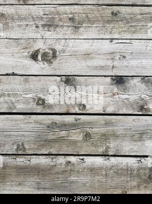 Ein Holzbodenhintergrund mit Anzeichen von Abnutzung und rostenden Nägeln, die aus der Oberfläche hervorstehen Stockfoto