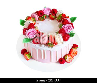 Süßer Geburtstagskuchen mit Beeren, Makronen und Blumendekor isoliert auf weißem Hintergrund. Wunderschöner rosa Kuchen dekoriert mit Makronen, Himbeeren, s Stockfoto