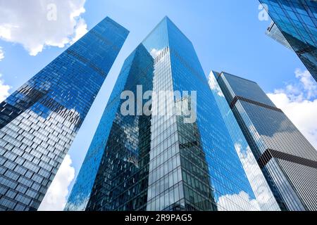 Moderne gläserne Silhouetten von Wolkenkratzern in der Stadt. Blick von unten auf moderne Wolkenkratzer im Geschäftsviertel. Stockfoto