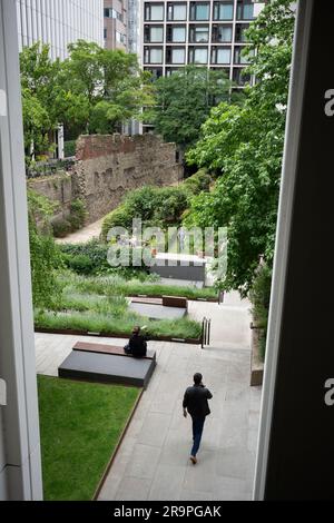 Stadtarbeiter genießen den relativen Frieden der modernen Metropole im Salters' Garden unter den Überresten der alten römischen Mauer, die einst die Grenze der antiken Stadt Londinium bildete - aber jetzt mit der Quadratmeile der Stadt London aus dem 21. Jahrhundert, Das Finanzviertel der Hauptstadt am 27. Juni 2023 in London, England. Die römische Mauer wurde zwischen 190 und 225 als defensive Mauer aus Stein um die Landseite der Stadt errichtet. Die Londoner Mauer war eines der größten Bauprojekte, die in römischem Großbritannien durchgeführt wurden und etwa 85.000 Tonnen Lumpen aus Kentish erforderten Stockfoto