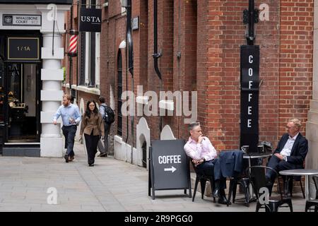 Zwei Geschäftsleute machen am Nachmittag eine Kaffeepause in der Telegraph Street in der City of London, dem Finanzviertel der Hauptstadt, am 27. Juni 2023 in London, England. Stockfoto