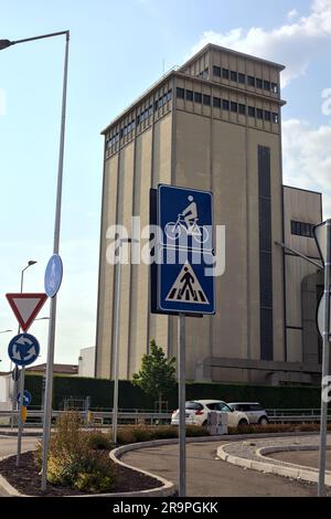 Hoher Turm am Rand einer Landstraße neben einem Kreisverkehr an einem sonnigen Tag Stockfoto