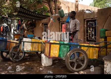 Nicolas Remene / Le Pictorium - Zugang zu Trinkwasser und Standrohren in Niamey, Niger - 28/4/2020 - Niger / Niamey / Niamey - Ein junger Nigerianer überträgt Wasser von einem Kanister in einen anderen, um eine Familie in Niamey zu versorgen, 28. April 2020. In Niamey, Niger, herrscht in der heißen Jahreszeit zwischen Anfang März und Ende Mai in vielen Stadtvierteln mehrmals täglich Wassermangel, und in einigen Randbezirken kann dieser Mangel mehrere Tage andauern. Das macht es für Bewohner sehr schwierig, ihr Getränk zu bekommen Stockfoto