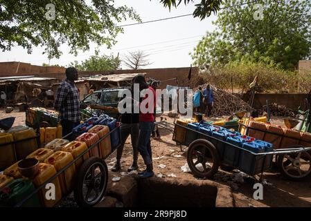 Nicolas Remene / Le Pictorium - Zugang zu Trinkwasser und Standrohren in Niamey, Niger - 28/4/2020 - Niger / Niamey / Niamey - Ein junger Nigerianer überträgt Wasser von einem Kanister in einen anderen, um eine Familie in Niamey zu versorgen, 28. April 2020. In Niamey, Niger, herrscht in der heißen Jahreszeit zwischen Anfang März und Ende Mai in vielen Stadtvierteln mehrmals täglich Wassermangel, und in einigen Randbezirken kann dieser Mangel mehrere Tage andauern. Das macht es für Bewohner sehr schwierig, ihr Getränk zu bekommen Stockfoto