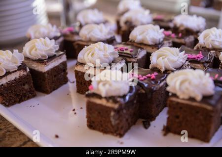 Verschiedene Kuchen, Gebäck und kleine süße Desserts mit Erdbeeren in einem Restaurant-Buffet aus nächster Nähe Stockfoto