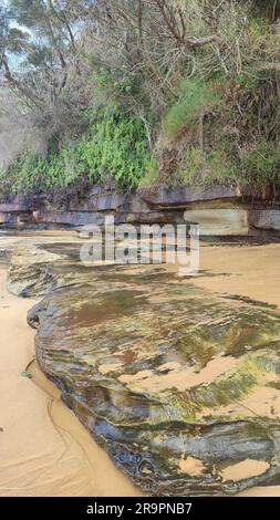 Bateau Bay Beach, offener Strand und weiße Wellen mit einer Rückansicht von 2 Personen im Vordergrund. Stockfoto