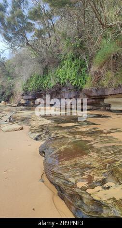 Bateau Bay Beach, offener Strand und weiße Wellen mit einer Rückansicht von 2 Personen im Vordergrund. Stockfoto