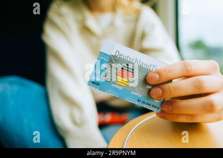 DeutschlandTicket in Händen, Frau mit neuer deutscher Abo-Reisekarte. Stockfoto