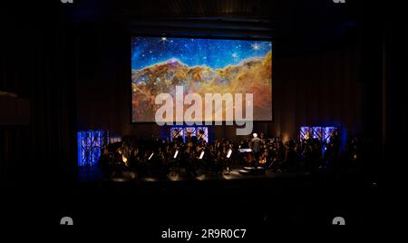 National Philharmonic führt kosmische Zyklen auf: Eine Weltraumsymphonie. Maestro Piotr Gajewski dirigiert die Nationalphilharmonie in der weltbesten Darbietung von Henry Dehlingers "Cosmic Cycles", Donnerstag, 11. Mai 2023, in Capital One Hall in Tysons, Virginia „Cosmic Cycles: A Space Symphony“ ist eine Zusammenarbeit zwischen dem Komponisten Henry Dehlinger, dem Goddard Space Flight Center der NASA, und der National Philharmonic, die in sieben Multimedia-Werken über Sonne, Erde, Mond, Planeten und Kosmos eine Fusion von Musik und Video bietet. Stockfoto