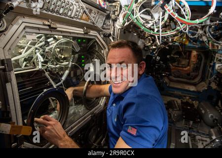 . Iss068e037083 (4. Januar 2022) - NASA-Astronaut und Expedition 68-Flugingenieur Josh Cassada tauscht Proben in der Mikrogravitationswissenschaft-Glovebox für die Untersuchung der Porenbildung und Mobilität aus. Die Studie zur Raumphysik zeigt ein passives Kühlsystem für elektronische Geräte in Mikroschwerkraft mit einer mikrostrukturierten Oberfläche. Stockfoto