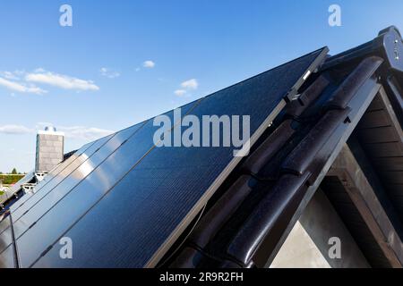 Moderne Sonnenkollektoren auf einem Giebeldach Stockfoto