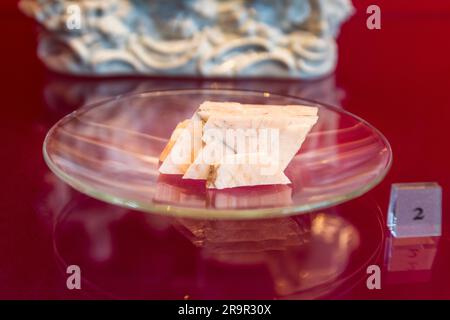 Mineralische Rohstoffproben für die Porzellanherstellung, markiert mit der Nummer „2“, liegen auf einem Glasbrett im Porzellanmuseum der Porzellanstiftung Meissen, Sachsen, Deutschland. Porzellanpaste wird aus einer Kombination von Kaolin, Feldspat und Quarz hergestellt. Stockfoto