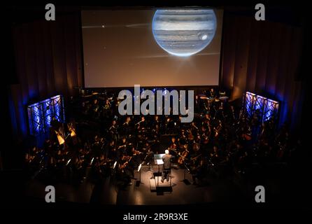 National Philharmonic führt kosmische Zyklen auf: Eine Weltraumsymphonie. Maestro Piotr Gajewski dirigiert die Nationalphilharmonie in der weltbesten Darbietung von Henry Dehlingers "Cosmic Cycles", Donnerstag, 11. Mai 2023, in Capital One Hall in Tysons, Virginia „Cosmic Cycles: A Space Symphony“ ist eine Zusammenarbeit zwischen dem Komponisten Henry Dehlinger, dem Goddard Space Flight Center der NASA, und der National Philharmonic, die in sieben Multimedia-Werken über Sonne, Erde, Mond, Planeten und Kosmos eine Fusion von Musik und Video bietet. Stockfoto