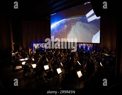 National Philharmonic führt kosmische Zyklen auf: Eine Weltraumsymphonie. Maestro Piotr Gajewski dirigiert die Nationalphilharmonie in der weltbesten Darbietung von Henry Dehlingers "Cosmic Cycles", Donnerstag, 11. Mai 2023, in Capital One Hall in Tysons, Virginia „Cosmic Cycles: A Space Symphony“ ist eine Zusammenarbeit zwischen dem Komponisten Henry Dehlinger, dem Goddard Space Flight Center der NASA, und der National Philharmonic, die in sieben Multimedia-Werken über Sonne, Erde, Mond, Planeten und Kosmos eine Fusion von Musik und Video bietet. Stockfoto