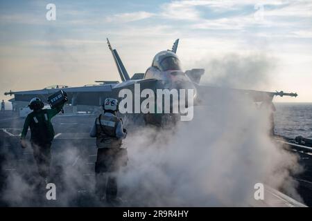 USS Nimitz, internationale Gewässer. 01. Mai 2023. USA Navy-Matrosen leiten ein F/A-18F Super Hornet-Kampfflugzeug vom mächtigen Sturmjäger der Streikkämpfer-Staffel 94 in Position zum Start auf dem Cockpit des Flugzeugträgers USS Nimitz der Nimitz-Klasse, der am 1. Mai 2023 Routineeinsätze am Südchinesischen Meer durchführt. Kredit: MC2 Justin McTaggart/U.S Navy Photo/Alamy Live News Stockfoto