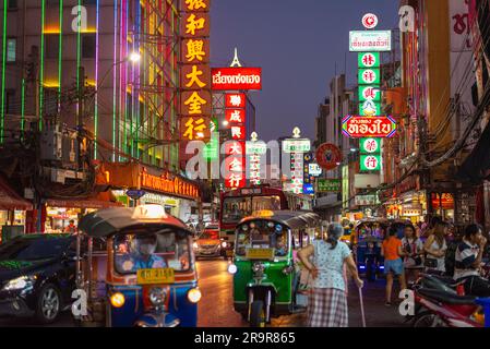 Bangkok, Thailand - 27. März 2023: Night Yaowarat Road mit chinesischen Schildern, Straßenverkehr und Wandermassen. Stockfoto