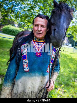 Neu Damerow, Deutschland. 27. Juni 2023. Der 72-jährige „professionelle Indianer“ Wolfgang Kring steht mit seinem Pferd während des Trainings für die jetzt 30. Apache Live Show in der ReitArena. Auf der natürlichen Bühne im Mecklenburger Seengebiet feiert das aktuelle Stück seine Premiere am letzten Wochenende im Juli. An insgesamt drei Wochenenden sind insgesamt sechs Vorstellungen mit rund 30 Amateurdarstellern geplant. Die fiktive Geschichte spielt in der Zeit des beginnenden Amerikanischen Bürgerkriegs in der Mitte des 19. Jahrhunderts. Kredit: Jens Büttner/dpa/Alamy Live News Stockfoto