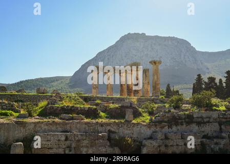 Archäologische Stätte von Korinth und Tempel des Apollo mit Festung Akrocorinth als Hintergrund. Stockfoto